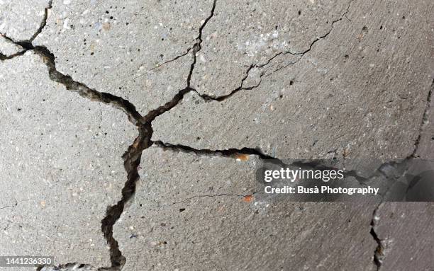 detail of cracked concrete surface - cracked stock-fotos und bilder