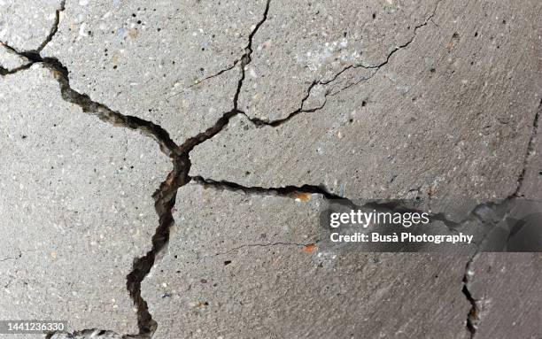 detail of cracked concrete surface - verval stockfoto's en -beelden