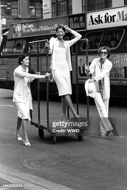 Models wearing outfits from the Calvin Klein spring 1974 ready to wear collection, ride a dolley down Seventh Avenue.