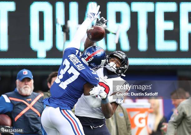 Fabian Moreau of the New York Giants intercepts a pass intended for Nico Collins of the Houston Texans during the first quarter of the game at...