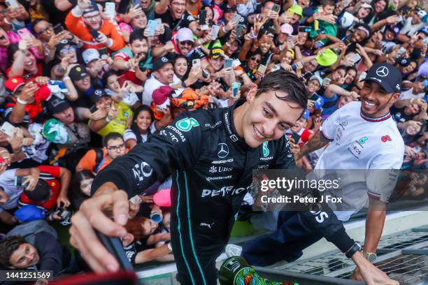 George Russell of Mercedes and Great Britain and Lewis Hamilton of Mercedes and Great Britain taking a selfie with the fans during the F1 Grand Prix...