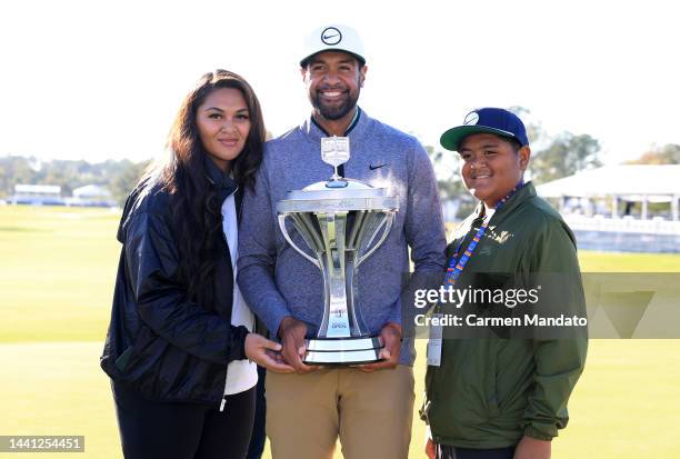 Tony Finau of the United States poses with the trophy and his wife Alayna and son Drace after putting in to win on the 18th hole during the final...