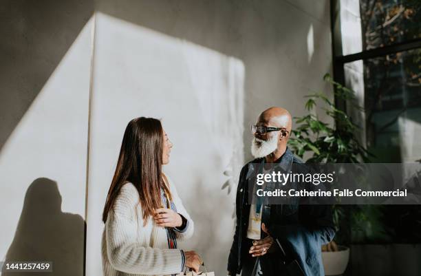 a man and a woman have a casual discussion in a modern environment - museum row fotografías e imágenes de stock