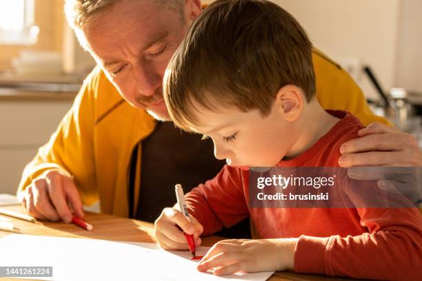 padre ayuda a su hijo de 5 años a aprender a dibujar - kid with markers fotografías e imágenes de stock