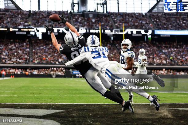 Foster Moreau of the Las Vegas Raiders completes a pass for a touchdown against Brandon Facyson of the Indianapolis Colts during an NFL game between...