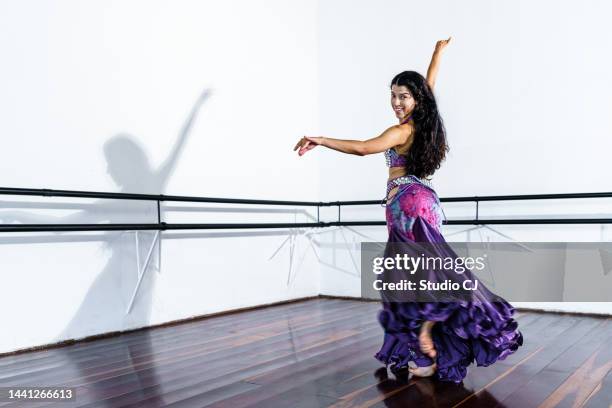 mujer joven realizando danza del vientre en la escuela de danza - belly dancer fotografías e imágenes de stock