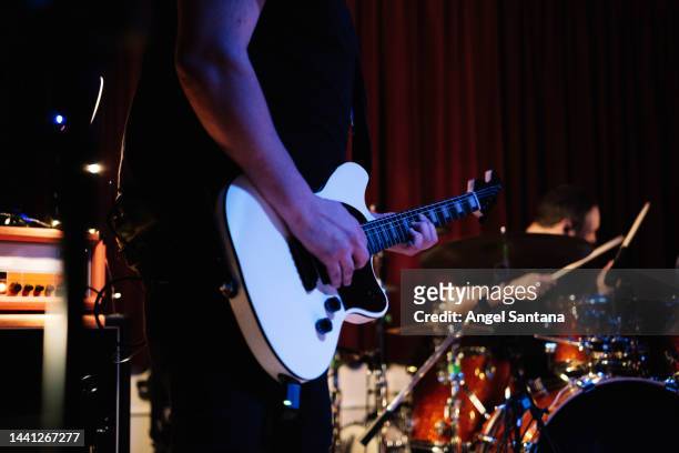 electric guitar player with rock and roll band performing hard rock music on stage - heavy metal music stock pictures, royalty-free photos & images
