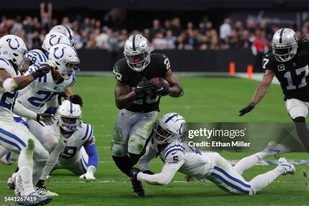 Running back Josh Jacobs of the Las Vegas Raiders runs for a first down as cornerback Stephon Gilmore of the Indianapolis Colts attempts a tackle...