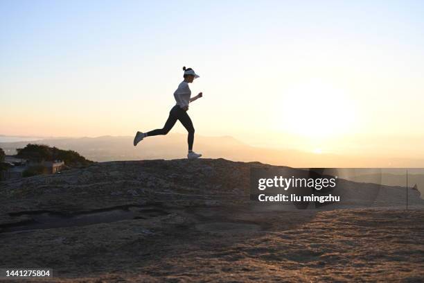 woman running on ridge - woman running silhouette stockfoto's en -beelden