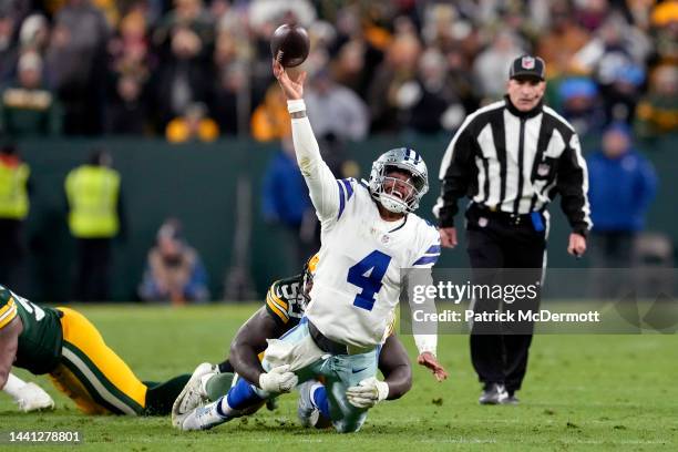 Dak Prescott of the Dallas Cowboys attempts a pass while being tackled by Jarran Reed of the Green Bay Packers during overtime at Lambeau Field on...