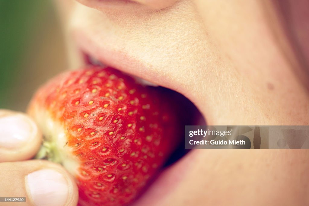 Woman eating strawberry