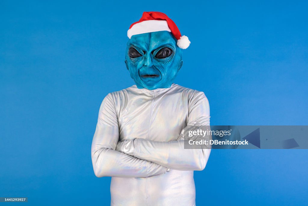 Person Dressed As A Blue Alien Wearing A Santa Claus Hat Celebrating ...