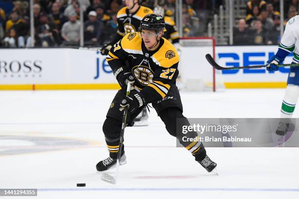 Hampus Lindholm of the Boston Bruins skates with the puck against the Vancouver Canucks at the TD Garden on November 13, 2022 in Boston,...