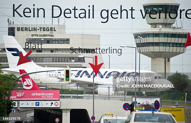 Finnair aircraft taxis past Berlin's Tegel behind an ad hanging on wires at Berlin's Tegel airport May 10, 2012. The scheduled opening of Berlin's...