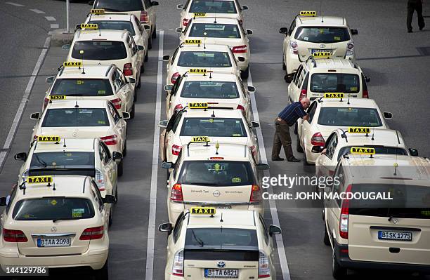 Rows of taxis wait to pick up passengers from the main terminal of Berlin's Tegel airport May 10, 2012. The scheduled opening of Berlin's new "Willy...