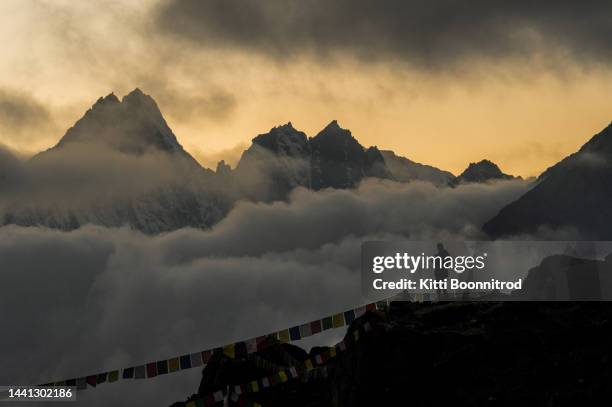 a man standing at sunset in himalayas range - everest camp 1 photos et images de collection
