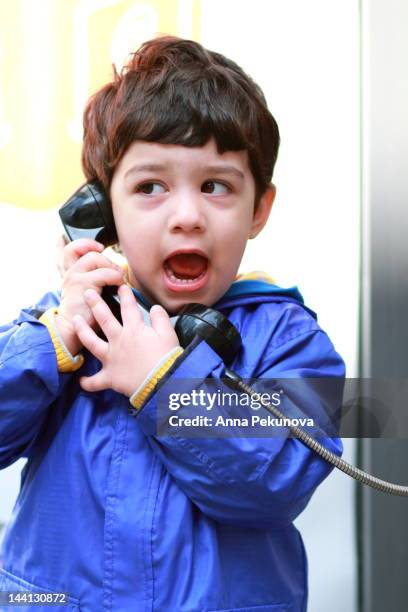 boy talking on street phone - pay phone stockfoto's en -beelden