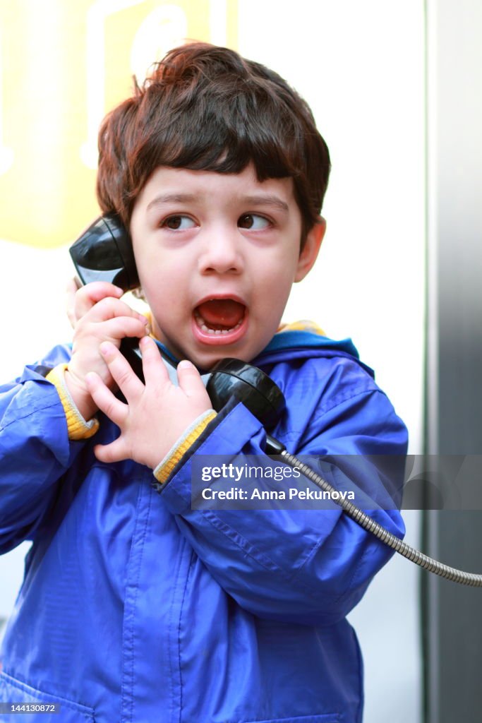 Boy talking on street phone