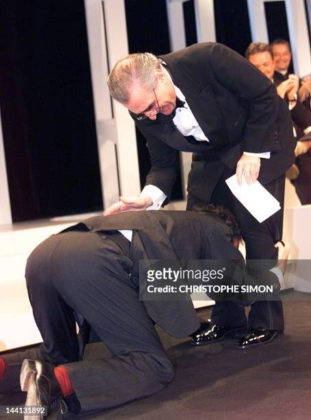 Italian director Roberto Benigni lays in front of US director and Jury president Martin Scorsese, 24 May at the final ceremony of the 51st Cannes...