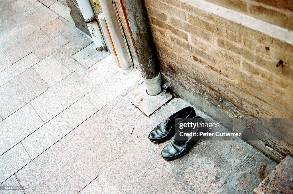 Empty shoes at sidewalk pavement