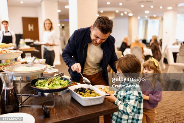 family enjoying breakfast buffet together in the hotel - buffet stockfoto's en -beelden