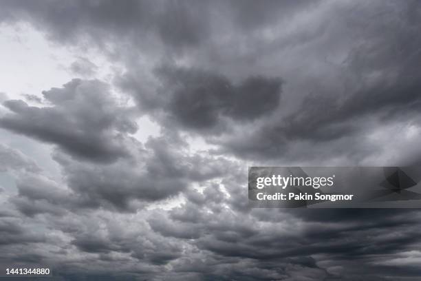 full frame of a low angle shot of a gray sky with clouds of rain. - dramatic sky stockfoto's en -beelden