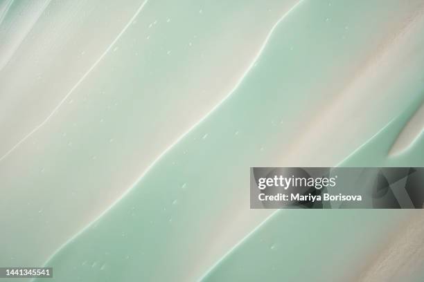 texture of green cream on beige background. - jojoba stockfoto's en -beelden