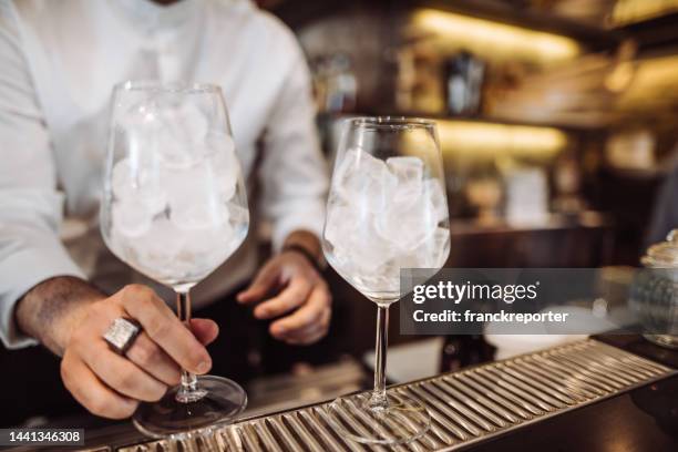bartender preparing a drink in front at the bar counter - aperol spritz stock pictures, royalty-free photos & images