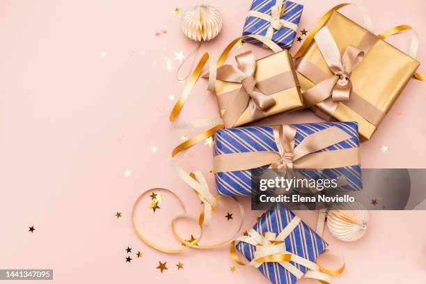gift wrapping festive christmas new year background colorful gift boxes and holiday decorations on wood background. new year's present and christmas present top view - red gold party stock-fotos und bilder