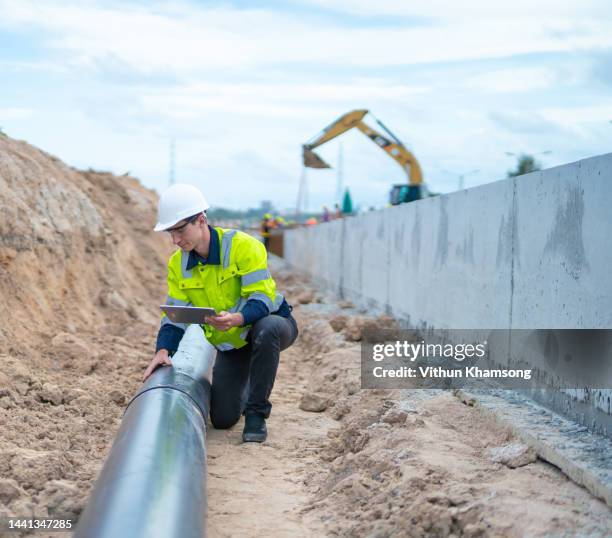 male engineer check quality pipe for drainage system at construction site. - waterleiding stockfoto's en -beelden