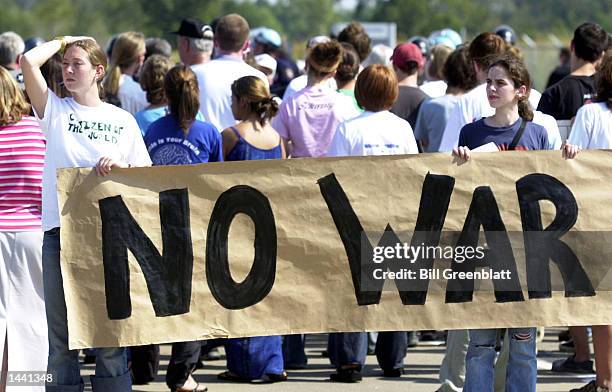 Protesters hold a sign at the entrance to the Boeing Missile Plant October 1, 2002 in St. Charles, Missouri. The non-violent protest was designed to...