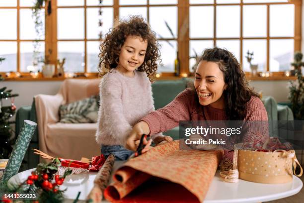 wrapping a christmas presents with my little helper - kado inpakken stockfoto's en -beelden