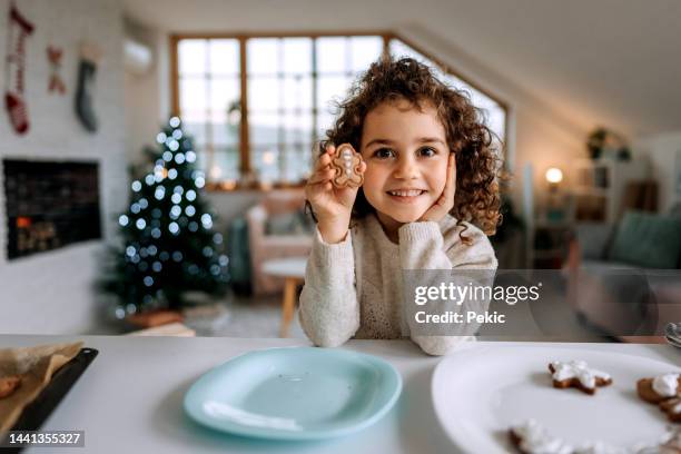 retrato de una linda niña con una galleta de jengibre - christmas cake fotografías e imágenes de stock