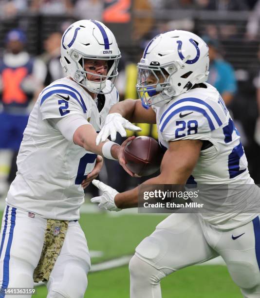 Quarterback Matt Ryan of the Indianapolis Colts hands the ball off to running back Jonathan Taylor in the first quarter of their game against the Las...