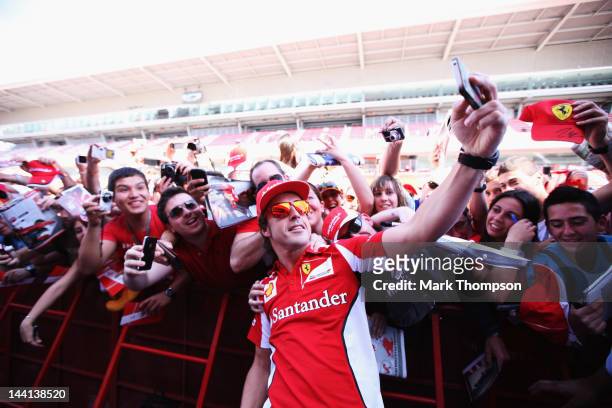 Fernando Alonso of Spain and Ferrari signs autographs for fans during previews to the Spanish Formula One Grand Prix at the Circuit de Catalunya on...
