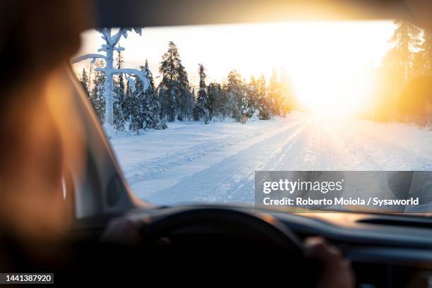 personal perspective of person driving a car on a snowy road - car interior sunset stock pictures, royalty-free photos & images