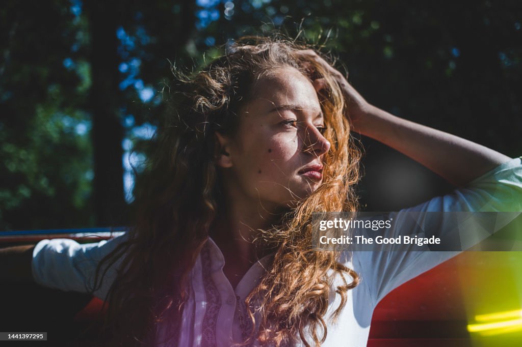 Female teenager with hand in hair on sunny day