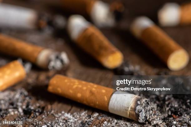 Cigarettes were burnt and smoking. World No Tobacco Day falls on May 31 of every year. Smoke cigarettes were smashed, Close-up shots On black wood floor.shallow focus effect. cigarettes were burnt smoking world no