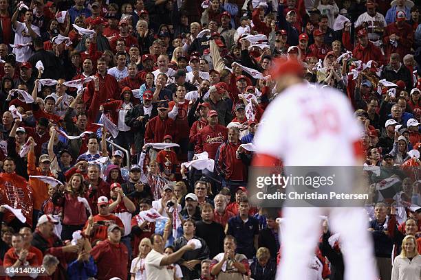 Jason Motte of the St. Louis Cardinals looks in for the sign as fans wave towels against the Milwaukee Brewers during Game Three of the National...