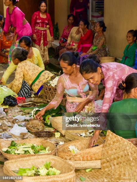 balinesische frauen bereiten opferkörbe vor - balinese culture stock-fotos und bilder