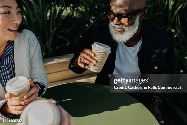 a group of colleagues sit at a table outdoors and enjoy some takeaway coffees - disposal container stock pictures, royalty-free photos & images