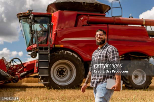 portrait of agronomist in front of agricultural machine - agricultural equipment stock pictures, royalty-free photos & images
