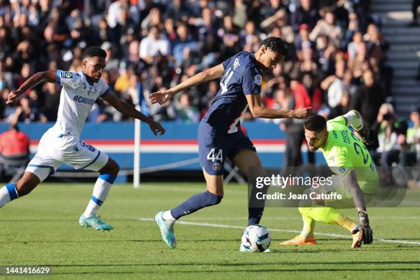 Hugo Ekitike of PSG facing goalkeeper of Auxerre Benoit Costil, left Rayan Raveloson of Auxerre during the Ligue 1 match between Paris Saint-Germain...