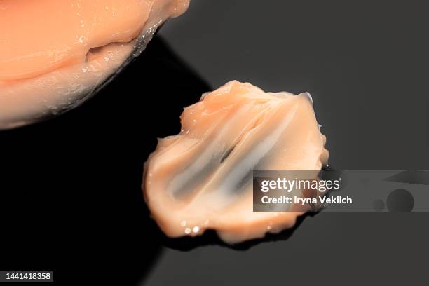 texture of delicate tea rose color smear of cosmetic product  hair mask or facial cream,  hand cream, bb face cream on black background. - black hair texture stock pictures, royalty-free photos & images