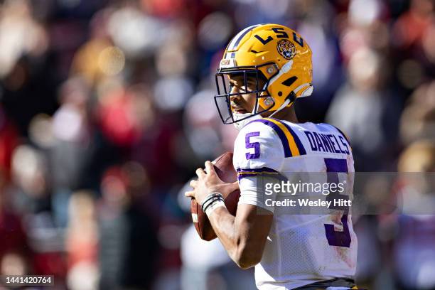 Jayden Daniels of the LSU Tigers drops back to pass during a game against the Arkansas Razorbacks at Donald W. Reynolds Razorback Stadium on November...