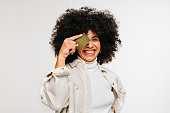 Happy young woman holding a credit card over her eye