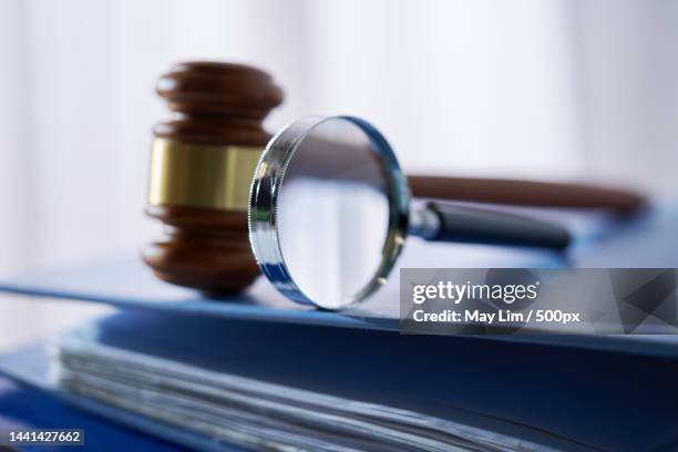 magnifying glass gavel hammer on stack of document,malaysia - government scrutiny stock pictures, royalty-free photos & images