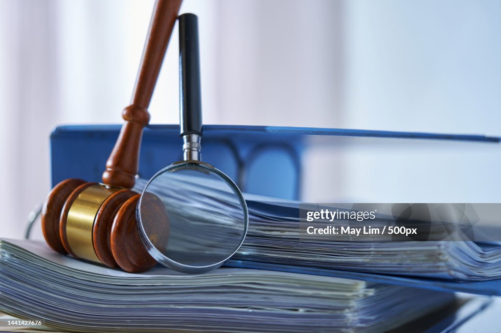 Magnifying glass gavel hammer on stack of document,Malaysia