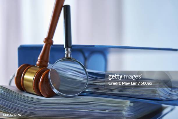 magnifying glass gavel hammer on stack of document,malaysia - government policy stock pictures, royalty-free photos & images