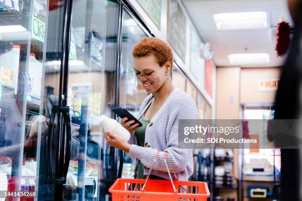 woman uses mobile app to scan label of milk container - american influencer stock pictures, royalty-free photos & images